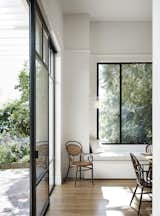 Dining, Table, Medium Hardwood, Chair, Wall, and Bench An eating area and window seat are washed with light.  Dining Medium Hardwood Chair Wall Bench Photos from Light Floods This Dazzling Renovated Victorian in Australia