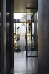 Hallway and Concrete Floor A view into the glassed interior courtyard, which brings nature inside on days with inhospitable weather.  Photo 9 of 12 in A Striking Black House Appears to Float in the New Zealand Mountains