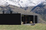 Exterior, Flat RoofLine, House Building Type, Metal Siding Material, Glass Siding Material, and Metal Roof Material In good weather, the owners can open up the exterior glass walls.  Photo 4 of 12 in A Striking Black House Appears to Float in the New Zealand Mountains