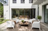 A limestone terrace beckons off the main living areas. The white outdoor chairs are from IKEA.