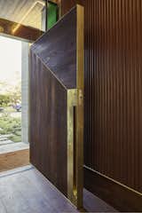 At the custom front door, textured wood is accented with un-lacquered brass to encourage patina with use. 