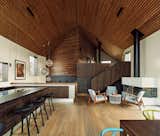 "They wanted a very practical house with separate zones for kids and adults," says architect Johanne Taugbøl of Wood Arkitektur + Design. "Because of the split levels, the experience of the space varies when you walk through it. The acoustics are also great due to the wood paneling in the ceiling." The Raimond pendant lights are from moooi, and the fireplace seating is from Ikea.