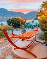 A striped hammock is perfectly placed for relaxing and taking in the sunset.