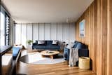 In the living room, the timber joinery continues and creates a sense of enclosure. The architects lined the opposite wall with a continuous bench seat to unify the open plan.