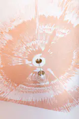 A unique spin art design in peach livens up the ceiling in a teen’s room.