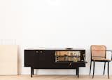 A drop-down door in Coil + Drift’s Rex credenza reveals a mirrored compartment ideal for barware display and storage.
