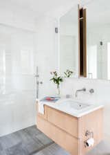 A custom white oak vanity and medicine cabinet adorn marble walls in the bathroom.
