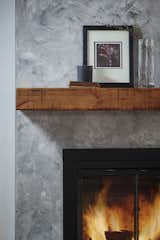 The fireplace received a dark gray venetian plaster finish and salvaged wood mantel.