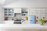 Kitchen appliances include a SMEG refrigerator, Bertazzoni Range Oven, and Bosch Dishwasher. The counters are honed white quartz, and the pendant over the island is the Cirrus Float by Edge Lighting.