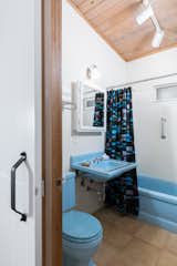 A hall bathroom with blue fixtures.