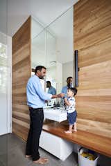 In the bathroom, wood-paneled walls mimic the striations in the rammed earth walls. The wood is wormy chestnut from Urban Salvage in Melbourne, and the counter is recycled blackbutt.