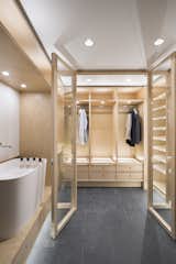 A dressing room continues the high-contrast theme with stone flooring and blonde wood fittings.