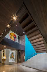 Wood stairs and walls warm up the double-height volume of the stairwell. Custom artwork can be found throughout the home.