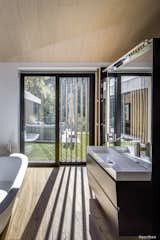 The wooden screens produce interesting shadows inside a bathroom and allow privacy from the adjacent terrace.