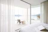 The bedroom all but merges with the landscape thanks to frameless sliding glass doors from Sky-Frame.&nbsp;&nbsp;