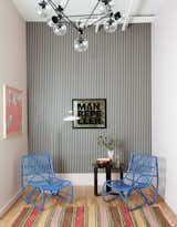 Blue rattan chairs and striped wallpaper greet visitors in the reception area. The artwork (on the left wall) is by Amber Vittoria.