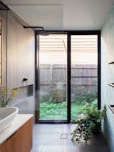 In the master suite bathroom, floor-to-ceiling glass connects the shower to a private side yard.