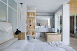 The bookshelf separating the bedroom and bathroom is the "Icon" system from "Sollos" by Brazilian designer Jader Almeida