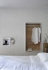 A clothing niche and the half-wall behind the bed are the same oak found throughout.