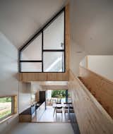 Wood cladding encases the ceiling of the kitchen at the lower level, covers the stairs, and defines the bedroom on the upper floor.