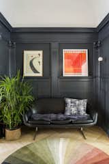 The space is now defined by a contrasting coat of Benjamin Moore Witching Hour. The cozy niche contains a vintage Overman loveseat and Pholc wall sconce.