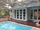Previously, the rear façade connected to a pool area that ran perpendicular to the house. Several sets of double doors with mullions impeded sightlines outside.