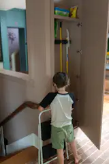 Built-in cabinetry in the mudroom stores cleaning supplies within easy reach.