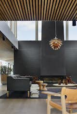 Now, a custom, steel-clad fireplace chimney stretches over 4.5 meters tall and imparts a sense of hygge. It was "designed as a contemporary take on the pressed copper flues typical of the era, while complementing and increasing the effect of the existing raked ceilings to the space," says the firm.