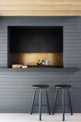 The backsplash is a tarnished sheet of bronze. Raft Stools by Norm Architects provide understated seating. 