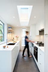 In the kitchen, white Caesarstone counters seamlessly top white flat-front cabinets.