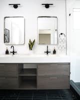 Sommer and Costello combined Derengge Two-Handle Faucets in matte black with the Lucent Light Shop Vortice Sconce over CB2 mirrors.