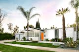 Maverick Design invigorated the facade of this 1962 Eichler in Orange, California, with vibrant orange Flaming Torch paint from Behr and attractive landscaping, which also plays a prominent role in the atrium.