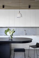 The kitchen backsplash features Yohen Border mosaic tile from Inax. Note the curved shape of the island. The stools are from Normann Copenhagen.