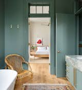 The adjoining bath is painted in Farrow &amp; Ball’s "Green Smoke."