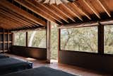 The screened porch functions as the building’s primary bedroom, creating a cabin-like experience.
