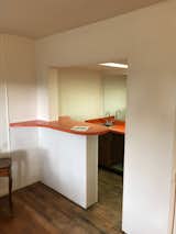 Before: The couple removed an existing kitchenette so they could put a new, larger kitchen against the concrete wall.