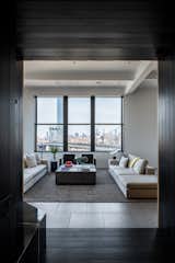 After: According to Yeung, in order to create an experience that didn't "give everything up at once," the firm shrouded the entry foyer in rich, dark materials, which inspires entrants to pause before stepping inside the apartment and catching sight of the skyline. "We wanted to take advantage of the explosion of light and view," says Yeung.