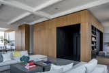 After: The architects defined the new entry sequence with black-stained paneling inserted within a white oak volume that has a vertical-raked pattern to the wood. A second white oak volume delineates the new kitchen.