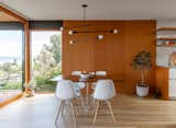 Vertical grain fir panels present a cohesive background for the table, which is surrounded by Eames chairs and illuminated by an Andrew Neyer light.