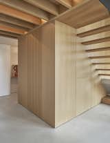 A utility core in the entry hall is also clad in wood for seamless integration.