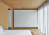 The walls are thickened by closet storage on two sides, which also controls the interior temperature and dampens sound.