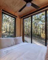 Large windows surround the queen-sized bed.