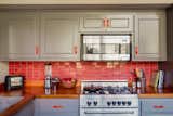Bailey integrated red and yellow accents throughout the cabin in a nod to its ’70s origins. Paprika-colored Heath tile bedecks the backsplash. The matte-black, enamel cast iron pan is by Crane Cookware.&nbsp;