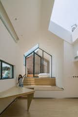 Occupants on the roof terrace can look down into the addition via the skylight. A narrow window over the table affords a view of the street, and the built-in table’s triangular shape saves space.