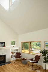The architects opened up the flat ceiling in the living room and inserted a multipurpose dormer. Ann Sacks tile now surrounds the fireplace.