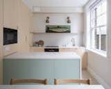 In the kitchen of a renovated London apartment building, bespoke plywood panels wrap IKEA cabinet inserts for a high-end feel on a budget. "The kitchen is a collection of very intricate details," says Astrain, who fitted the space down to the last available millimeter. The space benefits from two windows now, thanks to the relocated dining area. 