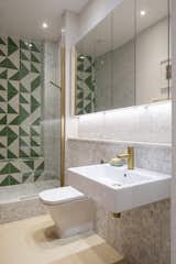 Astrain outfitted the relocated bathroom with marble mosaic tile and a punchy Bert and May Green Alalpardo tile in the shower as a graphic accent. "The client kept saying she liked geometric patterns—no flowers, etc.—and some bold color," says Astrain.