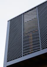 The privacy screen is composed of timber battens painted black and mounted on a steel frame.