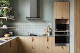 A warm palette of birch plywood with olive green linoleum outfits the kitchen. 