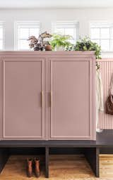 There’s now a storage locker for each member of the family. They sit atop a platform made of stained oak, like the kitchen island. The cabinet maker customized the molding detail to match the width of the pulls.